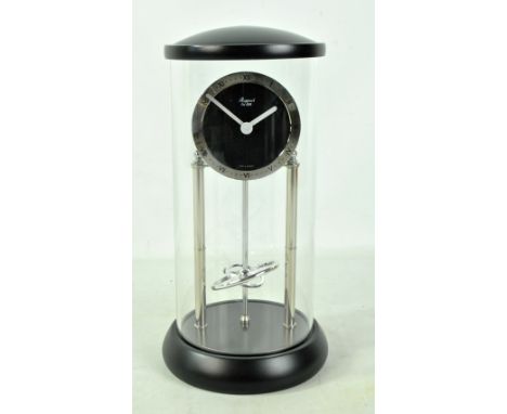 RAPPORT; a modern battery operated mantel clock with Roman numerals and perpetual motion effect mechanism, under glass dome, 