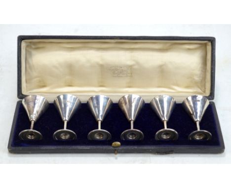 CHARLES EDWARDS; a cased set of six George V hallmarked silver&nbsp;conical tot cups, with gilt interiors, London 1916, heigh