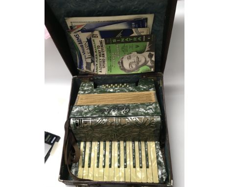 A cased Geraldâ€™s accordion with sheet music.