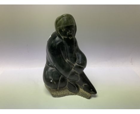 An Inuit art carved stone figure of an Eskimo fisherman, dated and marked to base 1975.