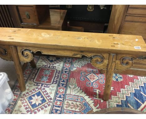 A Chinese carved wood low alter table the rectangular top above scroll supports. Height 50cm width 116cm