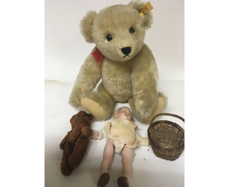 A Steiff bear the tag numbered 0165/38 an Early 20th century bisque child figure doll and one other smaller teddy bear (3)