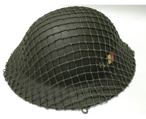 An army helmet covered in netting.