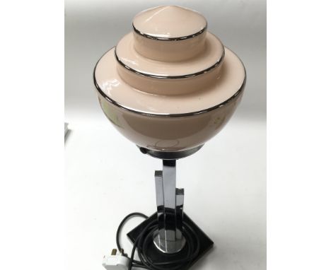 An Art Deco style lamp with a blush pink coloured glass tiered shade on chrome.