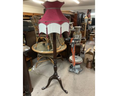 A 1920s mahogany tripod base standard lamp with shade.