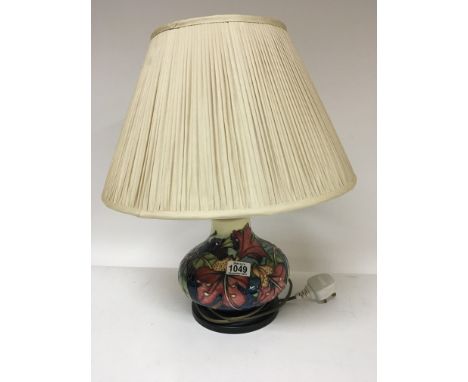 A modern Moorcroft lamp tubeline decorated with flowers and foliage with shade.