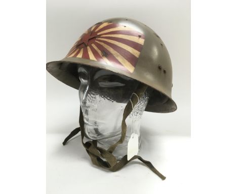 A WW2 Japanese type 90 helmet with Rising Sun insignia.