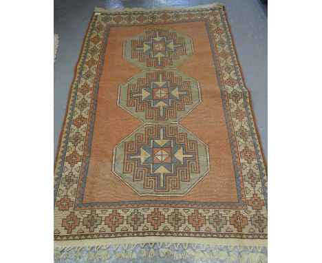 Turkish Kilim type carpet on a salmon ground with geometric medallion panels. (B.P. 21% + VAT)  Dimensions: 214x134cm approx.