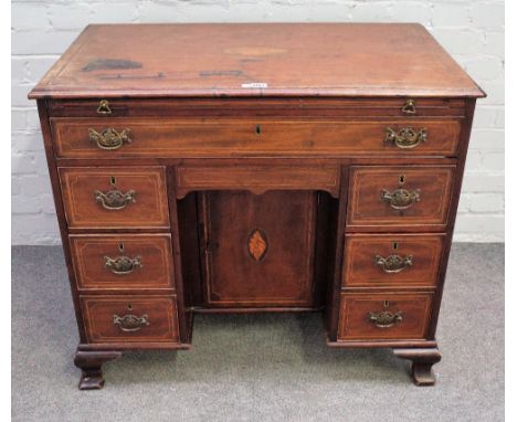 A mid-18th century inlaid mahogany kneehole writing desk with brushing slide over one long and seven short drawers about the 