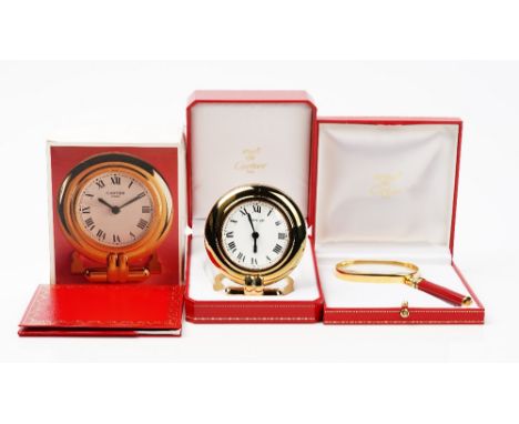 A Cartier 'colisee' quartz travel alarm clock, circa 1998, white dial with Roman numerals, to a gilt metal case with folding 