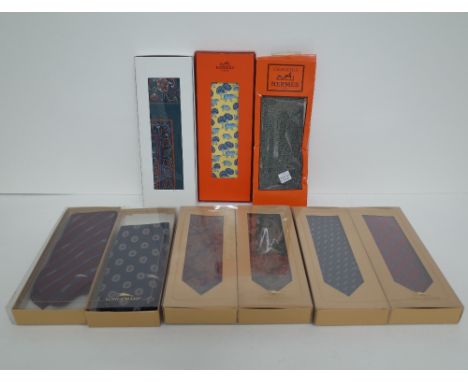 A Hermes of Paris pale yellow silk tie, printed all over in blues with cows beneath trees, contained within original packagin