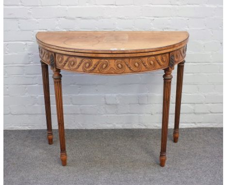 A late 19th century mahogany semi elliptic card table with carved frieze on tapering fluted supports, 92cm wide x 76cm high.