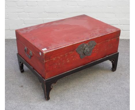 A 19th century Chinese scarlet lacquered rectangular trunk, on later ebonised stand, 78cm wide x 45cm high.