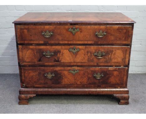 A George II featherbanded walnut chest with four long graduated drawers, on ogee bracket feet, 115cm wide x 91cm high. Condit