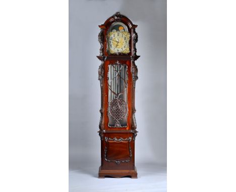 A large Edwardian mahogany three train quarter-chiming Longcase clockThe case carved all over with foliage, with an arched ho