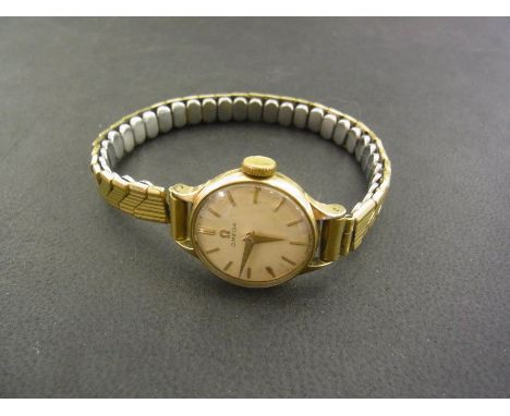 A 1950's Omega Ladies 9 ct wristwatch having cream dial with applied gilt stick markers and arrow hands,  upon rolled gold co