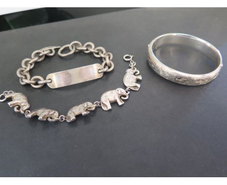 A silver hinged bangle - Hallmarked Birmingham - Inner diameter 6cms - A silver identity bracelet - Hallmarked London - Lengt