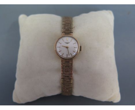 A 1960's Longines ladies 9ct gold cocktail watch with cream dial and applied gilt stick markers and pencil hands on bark effe