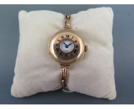 An early 20th century 18ct gold half Hunter style Ladies wristwatch having ceramic dial with Roman numerals and RED 12" secon