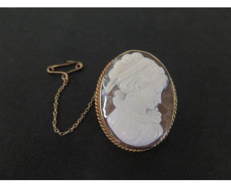 A 9ct gold shell cameo brooch - Carved to depict the profile of a lady, within a plain frame with rope-twist edging - Hallmar