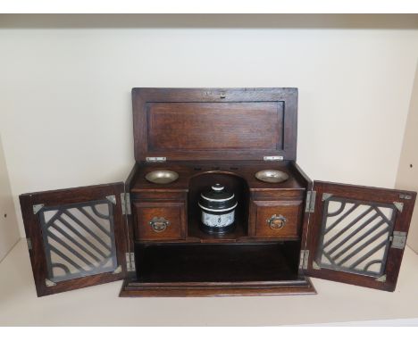 An oak smokers cabinet with accoutrements including ceramic mixing bowls, silver plated dishes and integral pipe rack - Width