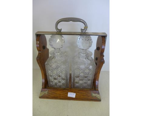 An oak two decanter Tantalus Betjemanns patent - one decanter has a chipped rim
Large chip to neck of one decanter, general w