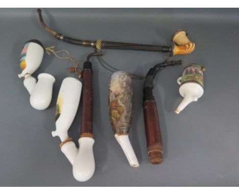 A collection of five pipes including an early 20th century porcelain pipe