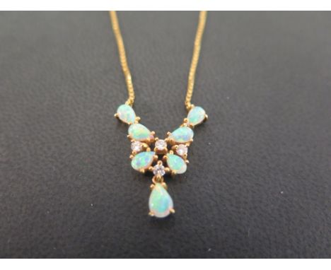 An 18ct gold opal and diamond necklace - The oval opal cabochons and brilliant-cut diamonds to the box-link chain - Hallmarke