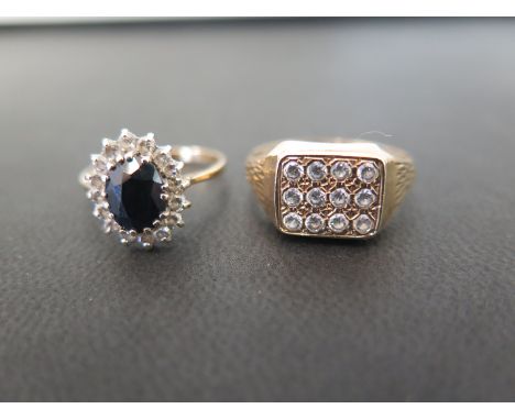 Two 9ct gold rings - To include a cubic zirconia panel ring - Hallmarked Birmingham - Size S - Together with a sapphire and c