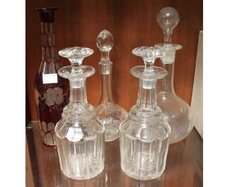 A pair of mallet decanters and stoppers, together with three other decanters including one ruby flashed example.