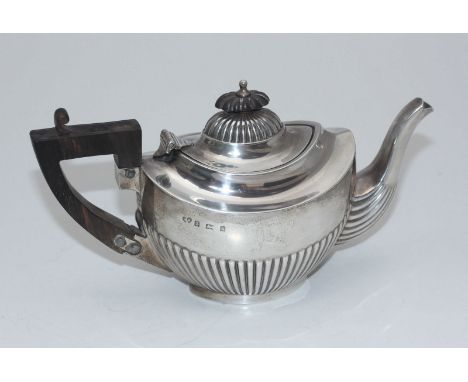 A silver teapot with half-gadrooned body, ebonised handle and finial, Birmingham, 1901, maker's mark of Williams Ltd?, approx