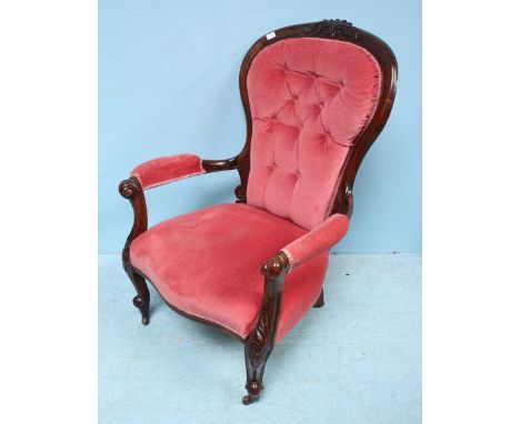 A Victorian carved and stained mahogany armchair, with pink fabric, button-back, frilled gimp and raised on cabriole front su