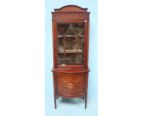 An Edwardian narrow bookcase with boxwood stringing and satinwood inlay, decorated with floral swags, arched pediment, single