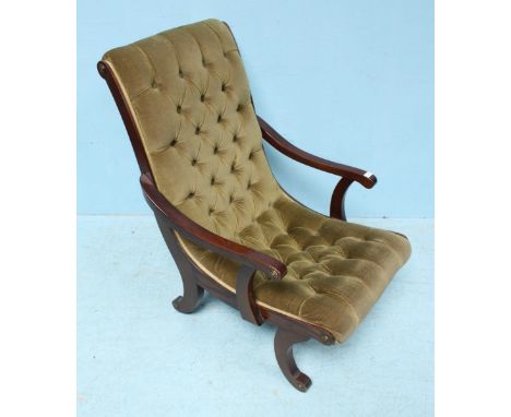 A stained mahogany armchair, the one-piece curved back and seat with green, deep-button fabric upholstery and raised on scrol