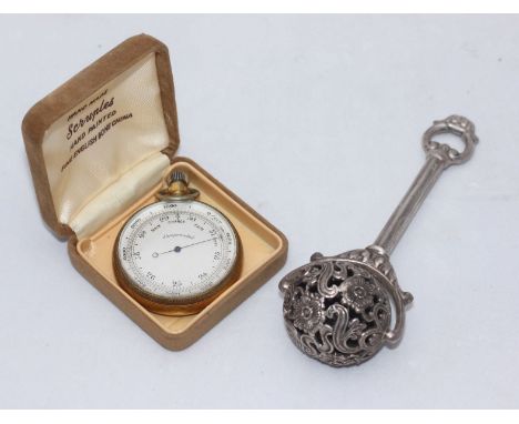 An Art Nouveau style Continental silver child's rattle with floral decoration, stamped 925, together with a brass-cased compe