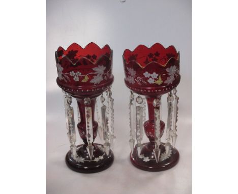 A pair of Victorian ruby glass lustres, enamelled with scrolling foliage, 34cm high; another smaller, 34cm high; a Victorian 