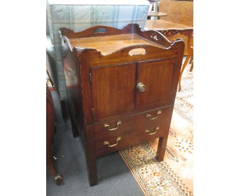 A George III mahogany bedside commode, with tray top and pierced carrying handles, the pull out commode with brass scroll han