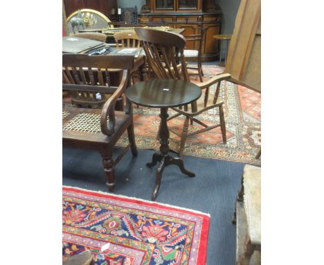 An oak circular tripod table, stamped Ercol  