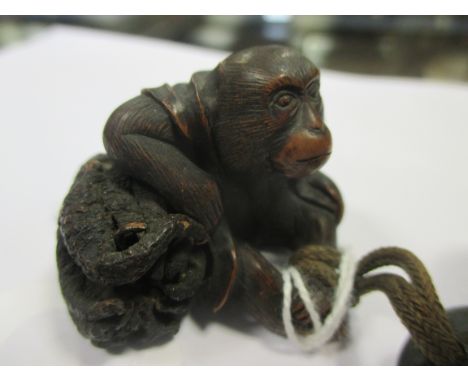 Two wooden netsuke , Meiji period One of them with remnant of red lacquer , a man carrying a child on his back , The second o