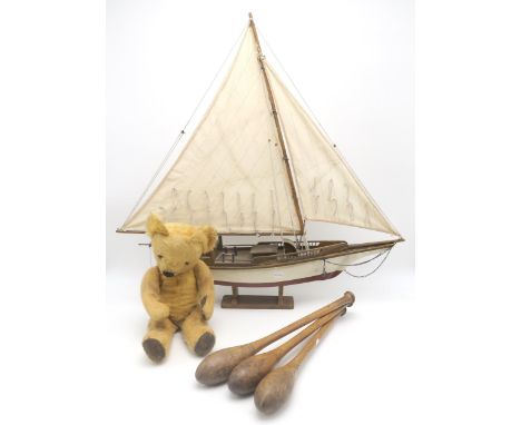 A large model sailing yacht, measuring approx. 64cm from tip of bowsprit to stern; a set of three Indian/juggling clubs and a