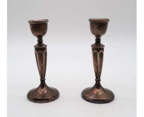 A pair of silver candlestick (weighted),&nbsp;Aaron Lufkin Dennison, Birmingham 1907, of tapering faceted form, with bell-sha