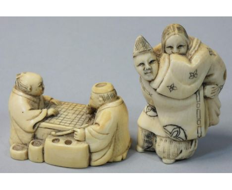 Two Japanese Ivory Netsuke, one carved as two men playing draughts, signed, height 3 cm, the other as a man carrying a woman 