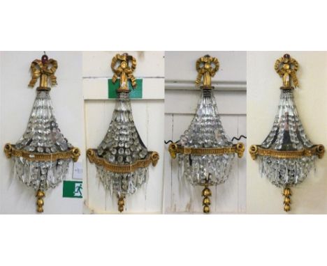An Edwardian set of four mirrored, cut glass and gilt wall light brackets, of shaped form, with swags and drops, 84 cm. 