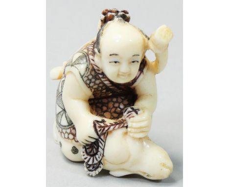 A Japanese Ivory Netsuke, carved and painted as a crouching bowman with a rabbit, height 4 cm. 