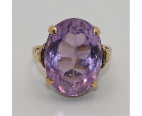 A 14 ct gold amethyst single stone ring, stamped 585, claw set with an oval mixed cut stone, 18 x 13 mm, size J 1/2.