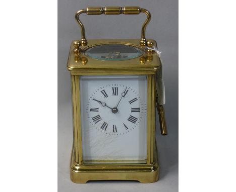 A brass cased striking carriage clock, wth white enamel dial with black Arabic numerals, the French movement striking on a go