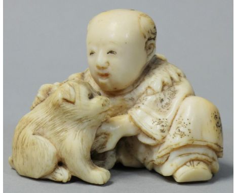 A Japanese Ivory Netsuke, carved in the form of a man with a dog, signed, height 3.5cm. 