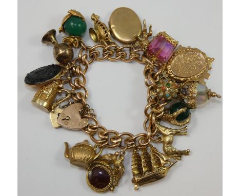 A 9ct rose gold multi charm hollow curb bracelet, mounted with various to include an enamel fob, a three mask ship and a hors