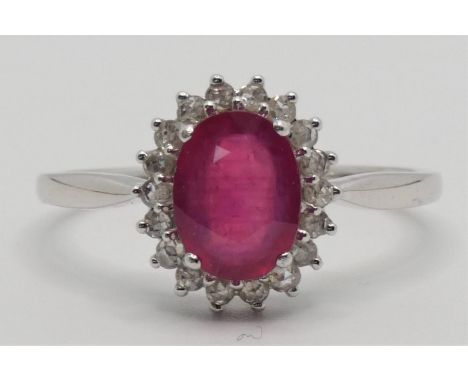 A 9k white gold, ruby and diamond cluster ring, claw set with a mixed cut stone, bordered by rose cuts, size O. 