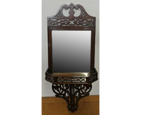 An Edwardian mahogany mirrored shelf, with fretwork surmount and support. bevelled glass, 64 cm. 